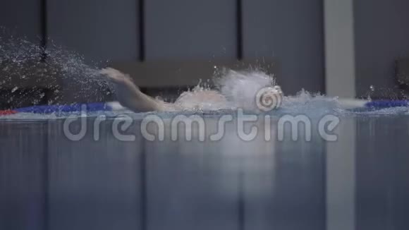 运动女子漂浮蝶泳蓝水游泳池前景视频的预览图