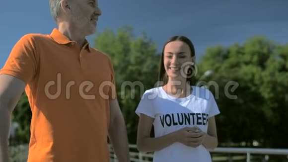 一位乐于助人的女志愿者和一位年长的男人散步视频的预览图