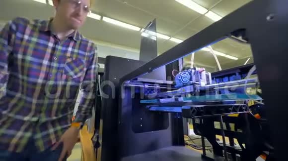 一个工程师过来查看一个大的3d打印机开始工作4K视频的预览图