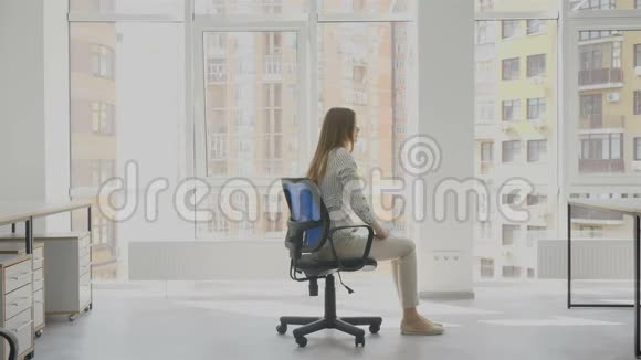 办公室工作人员年轻女子坐在椅子上手里拿着文件快乐地在椅子上旋转着视频的预览图