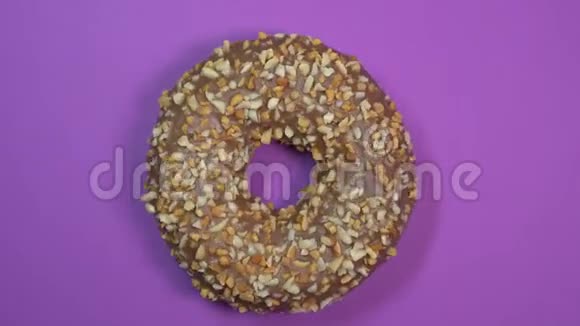 巧克力甜圈在盘子上旋转上景紫色背景视频的预览图