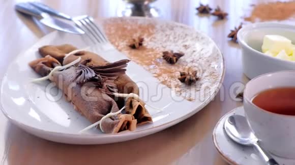 巧克力俄式薄饼布里尼和凝乳馅在盘子里提供了一杯茶和黄油侧视视频的预览图