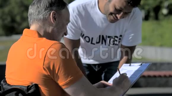 热心的志愿者帮助一个由轮椅驾驶的人填写信息视频的预览图