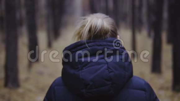 电影拍摄慢动作那个女孩穿着夹克沿着秋天的森林散步视频的预览图