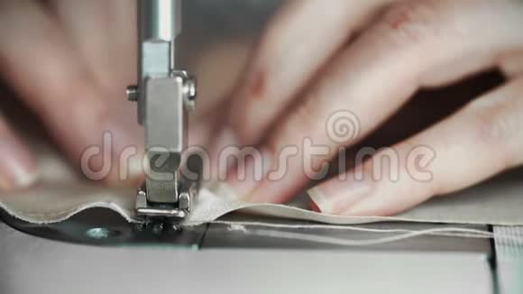 在缝纫机上工作的女性手的宏观镜头年轻女性的概念设计师在家里做缝纫机视频的预览图
