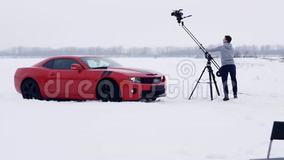 广告拍摄年轻人操作起重机拍摄红肌车视频的预览图