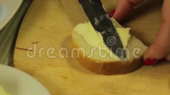 女性用手抹上白色黄油用黄油做罐头视频的预览图