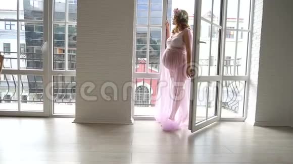 从阳台看城市景观的棕色长发孕妇形象视频的预览图