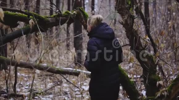 少女摄影师漫步秋林初雪慢动作视频的预览图