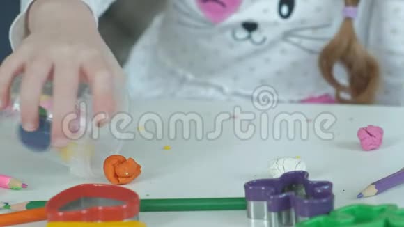 快乐的小女孩把五颜六色的塑料放在一个容器里桌面上是数字和彩色铅笔视频的预览图