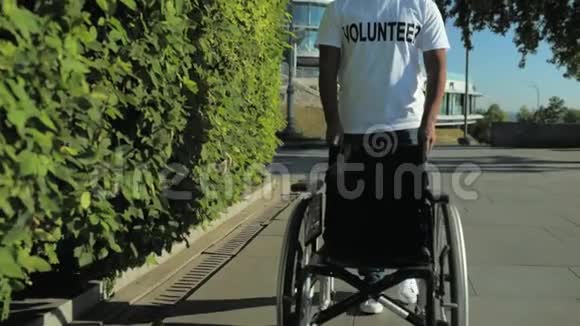 一位令人愉快的志愿者推着轮椅慢动作视频的预览图