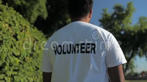 一位愉快的志愿者在公园里散步的镜头视频的预览图