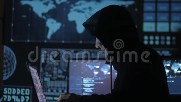 在充满显示屏的网络安全中心工作的hood的人极客黑客视频的预览图
