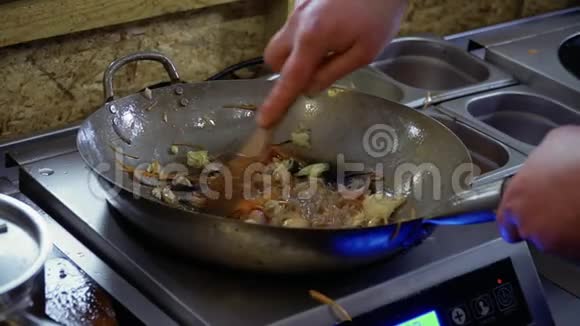 厨师把米粉和炒菜和锅铲混合在一起视频的预览图