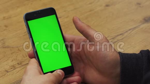 人使用垂直智能手机与绿色屏幕男人用手机手的特写镜头铬钥匙关门视频的预览图