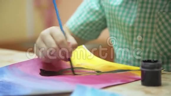 男孩用画笔在纸上画画视频的预览图