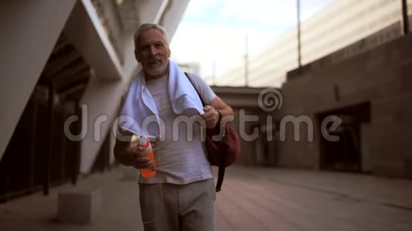 在体育锻炼后走路微笑的老人视频的预览图