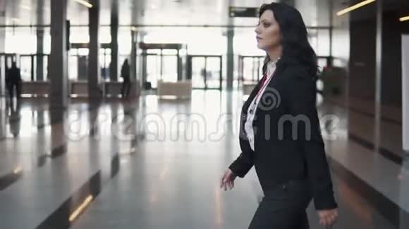 一位穿着西装的年轻女子穿过一座现代化办公楼的大厅视频的预览图