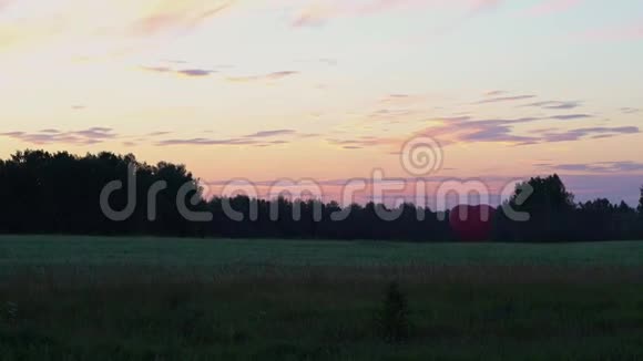 一颗心脏形状的红色喷雾器矗立在田野里的夕阳下视频的预览图