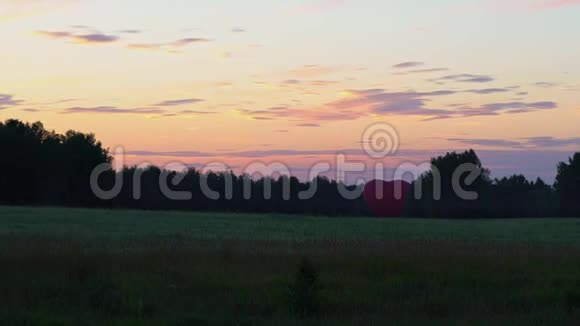 一颗心脏形状的红色喷雾器矗立在田野里的夕阳下视频的预览图