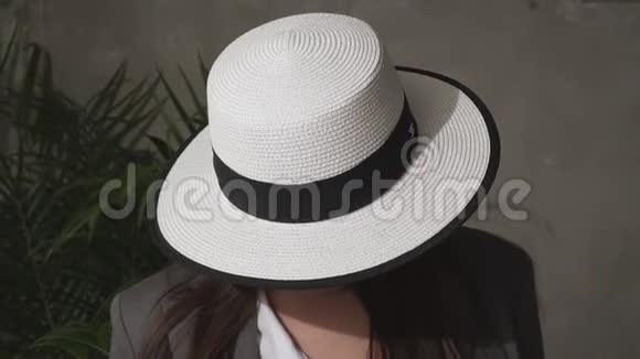 美丽的年轻黑发戴着优雅的帽子和商务套装视频的预览图