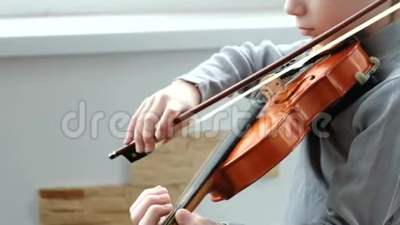 拉小提琴无法辨认的七岁男孩在拉小提琴特写视频的预览图