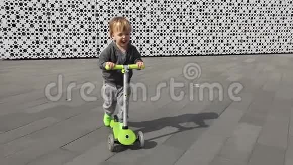 儿童骑绿色踢滑板车视频的预览图