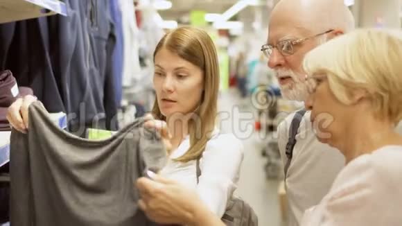 年长夫妇和他们的女儿在商场购物站在架子旁边的衣服视频的预览图
