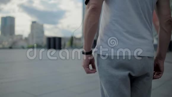 站在城市里的一个运动男子的后景视频的预览图
