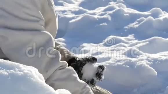 少年男孩玩雪做雪球冬天把雪扔在手里阳光明媚的冬日视频的预览图