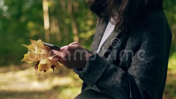 在秋天森林里发短信的年轻女子面目全非视频的预览图