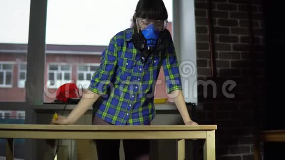 女木匠在车间用刷子从桌面上敲打木屑视频的预览图
