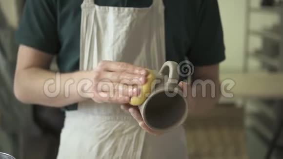 年轻陶工用海绵擦拭陶器车间视频的预览图