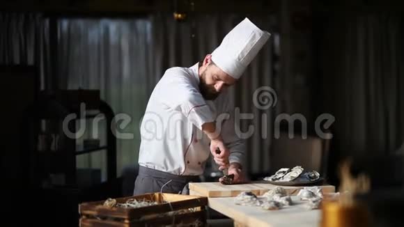 豪华餐厅的厨师打开牡蛎把它们放在装有冰块的盘子里视频的预览图