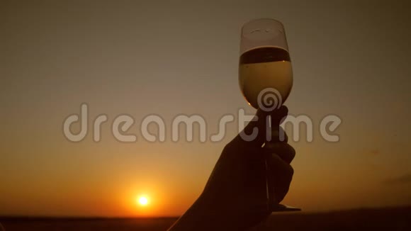 在夕阳红的背景下手里拿着香槟视频的预览图