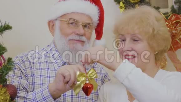 幸福的老夫妇装饰圣诞树视频的预览图