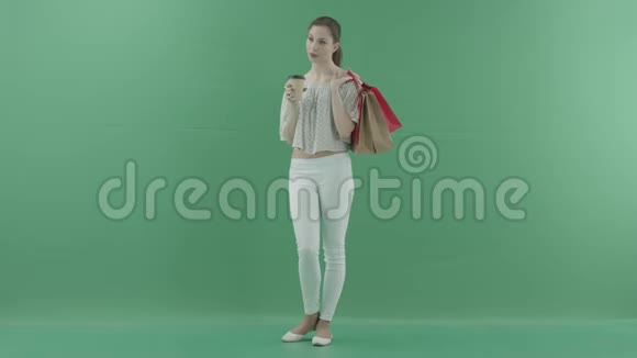 女人喝茶把袋子放在绿屏上视频的预览图