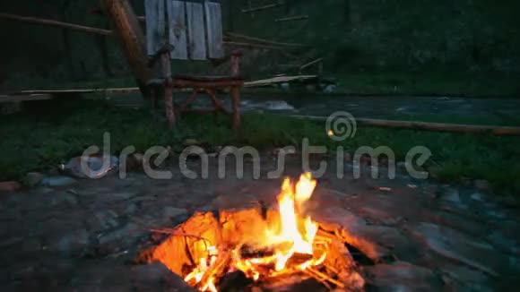 在户外火会燃烧在阿尔泰的一场大火中度过了美好的夜晚篝火在森林中燃烧湖边视频的预览图