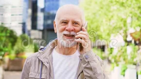 老人站在户外使用智能手机市中心商业背景条件视频的预览图