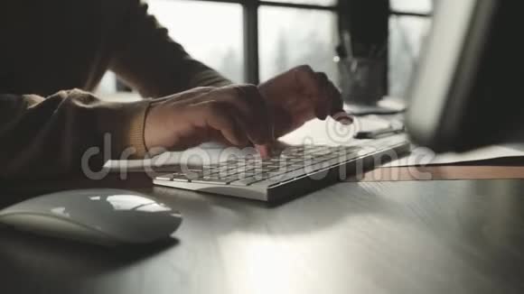 男人手拿着一件米色毛衣印在键盘上放在视频的预览图