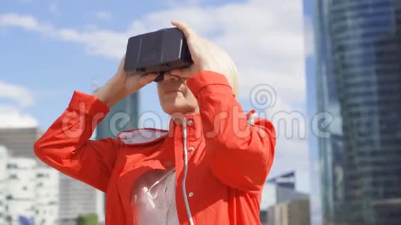 站在商界的资深女性使用虚拟现实眼镜背景摩天大楼视频的预览图