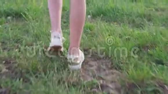 腿的小女孩走在草地上视频的预览图