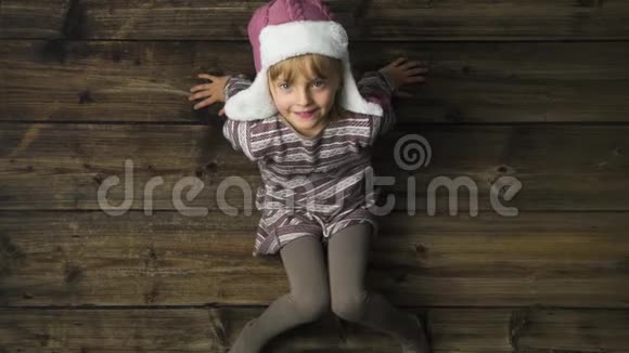 头顶上幸福微笑的儿童女孩戴着老式木制背景的帽子肖像文字或标志复制空间垂直顶部视频的预览图