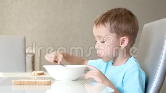 孩子坐在厨房的桌子旁吃汤健康宝宝食品的概念视频的预览图