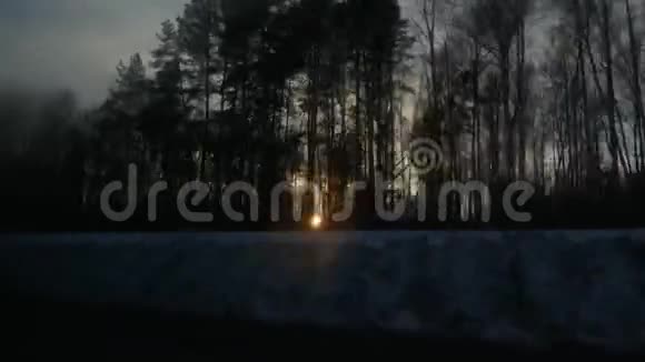 冬天白雪皑皑的路上阳光穿过树林视频的预览图