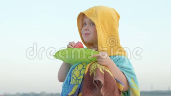 快乐的小女孩在海滩上吃西瓜片暑假户外野餐视频的预览图