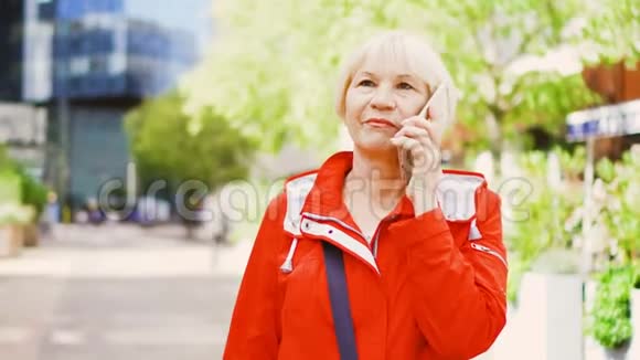 高级妇女站在户外使用智能手机市中心商业背景条件视频的预览图
