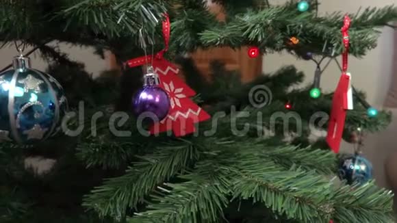 镜头聚焦在圣诞树上的圣诞装饰然后放在沙发上放松的女人身上视频的预览图