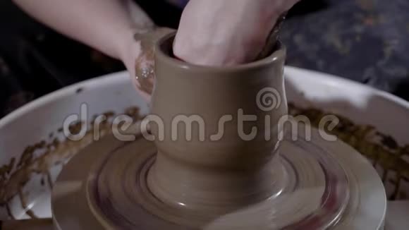 一个女人的手紧紧地拍着她从事陶器制作一个男人想在车间里做一个粘土花瓶视频的预览图