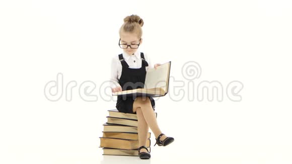 聪明的小女孩在白色背景下读大书视频的预览图